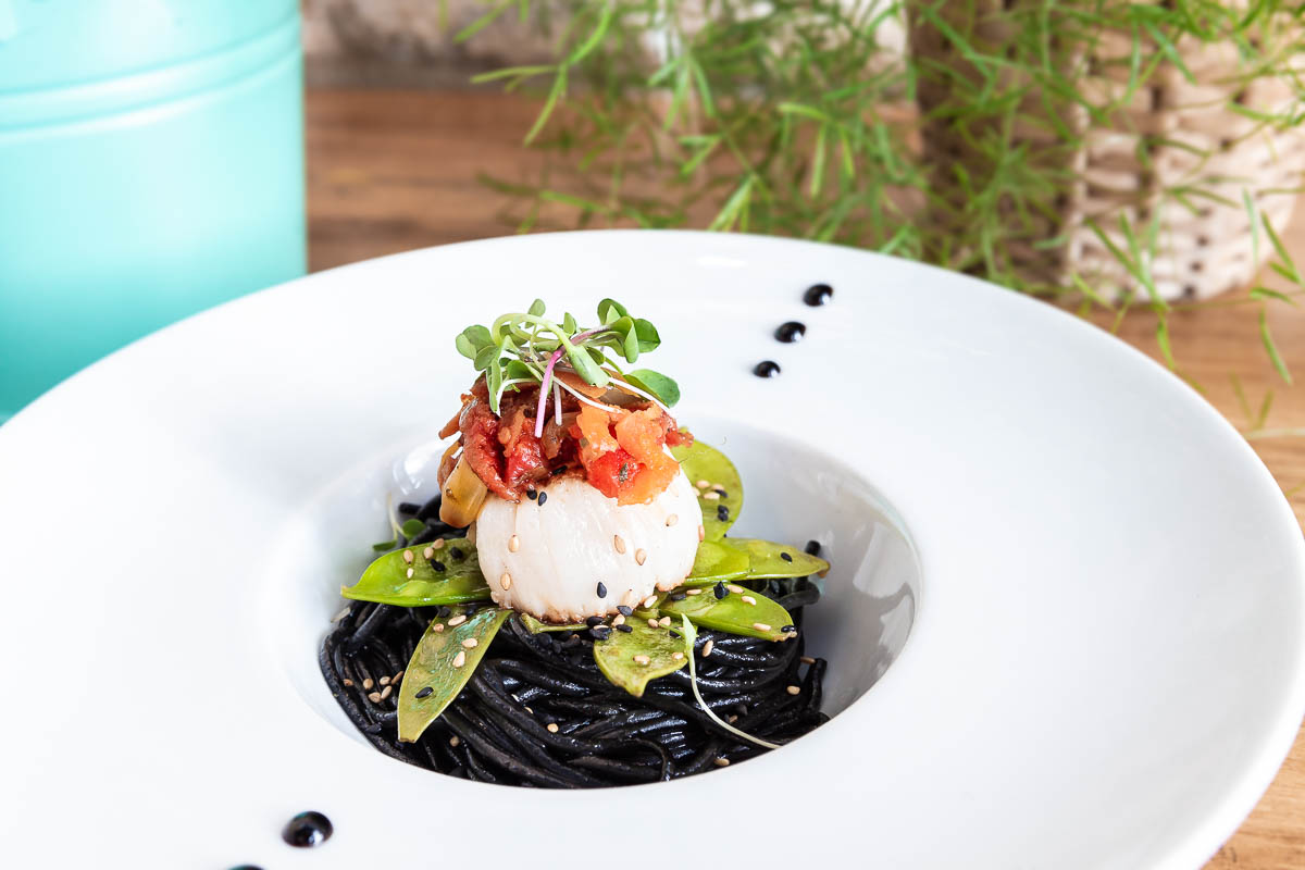 Vieira con tallarines negros, tirabeques y pesto de tomate