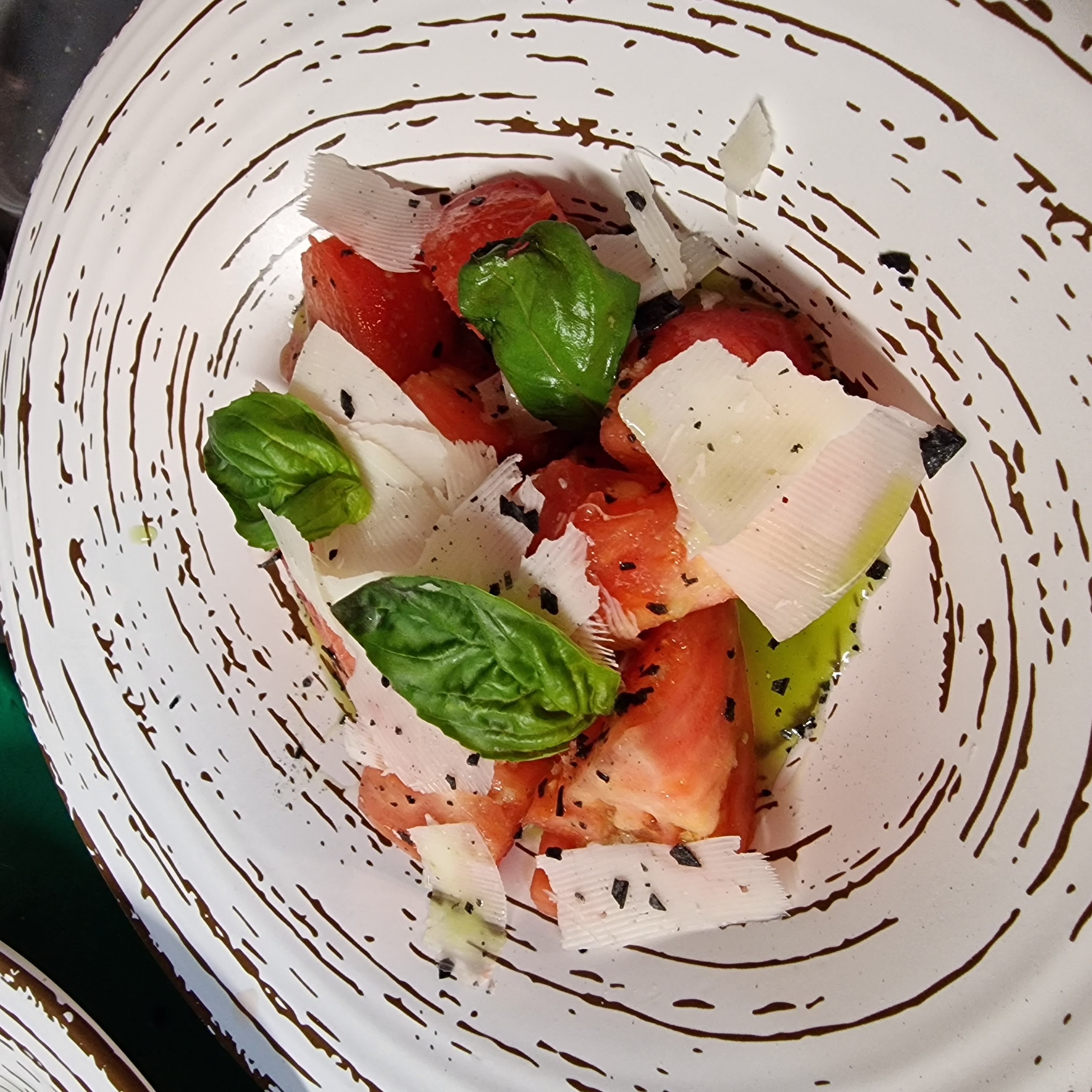 Pink tomato with slices of cured Payoyo cheese and Basil Oil