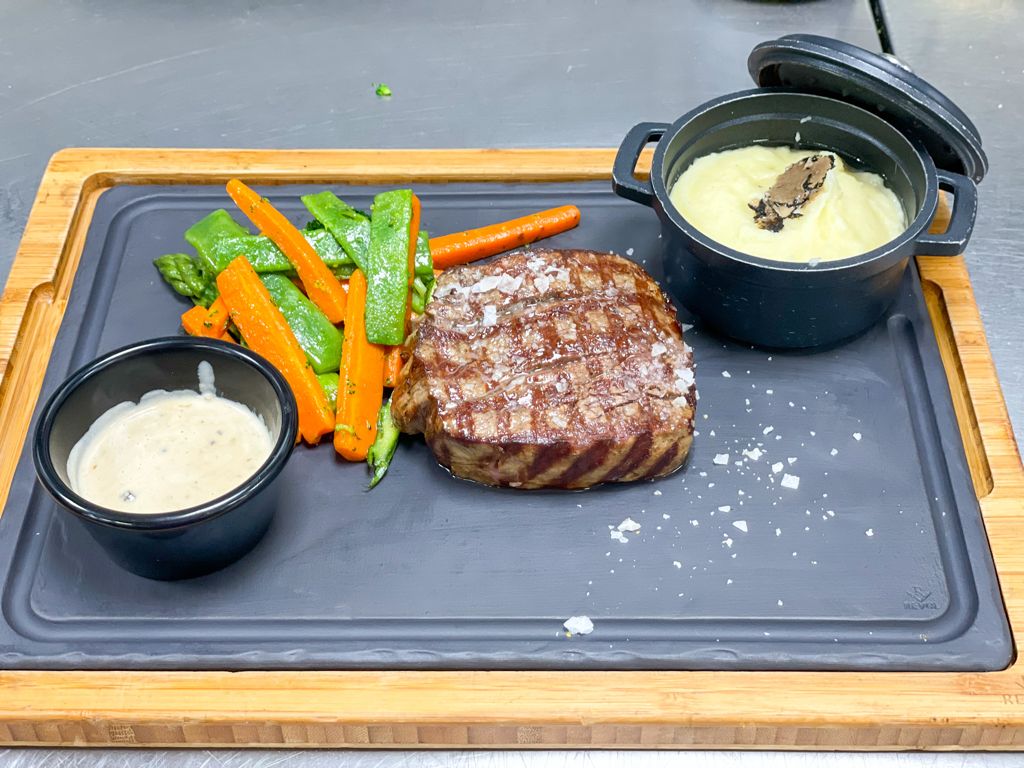 Grilled steak served truffled mashed potatoes and vegetables 