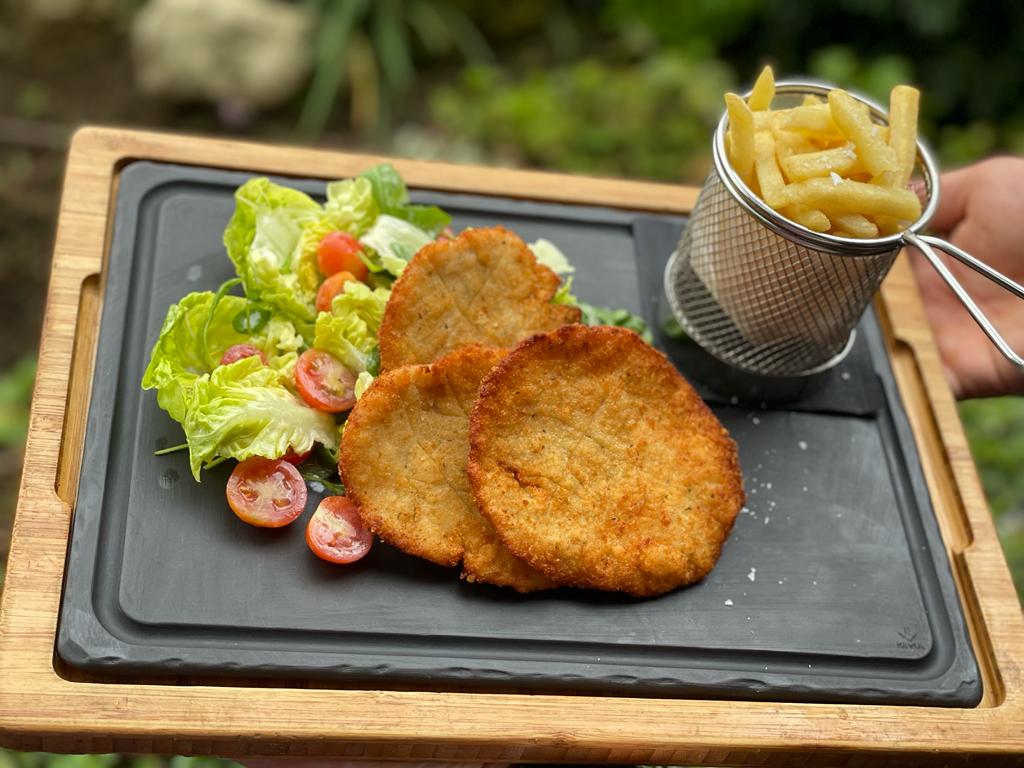 Italian breaded chicken cutlet served with French fries and vegetables 