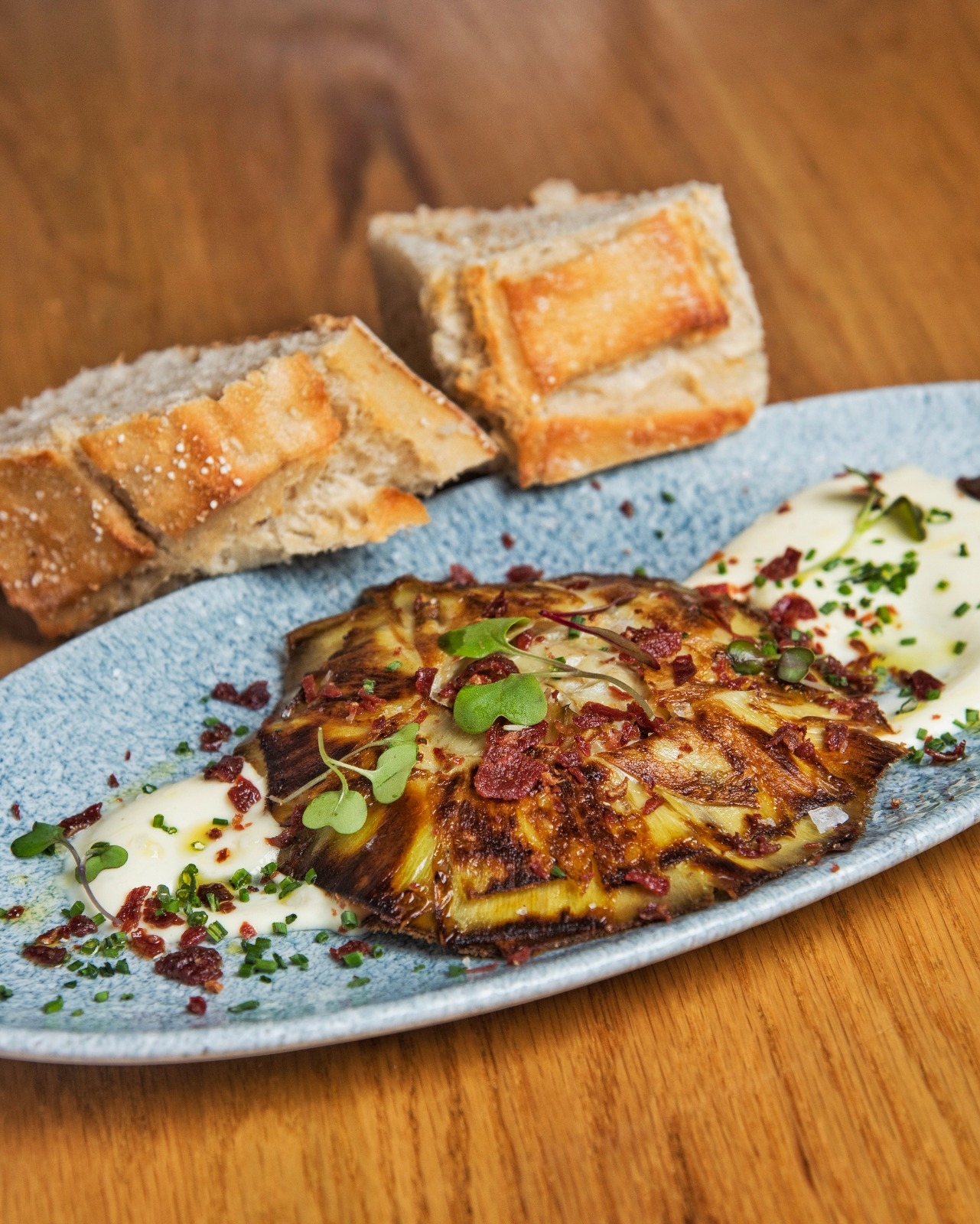 Alcachofa confitada a la plancha con jamón crujiente y crema de patata