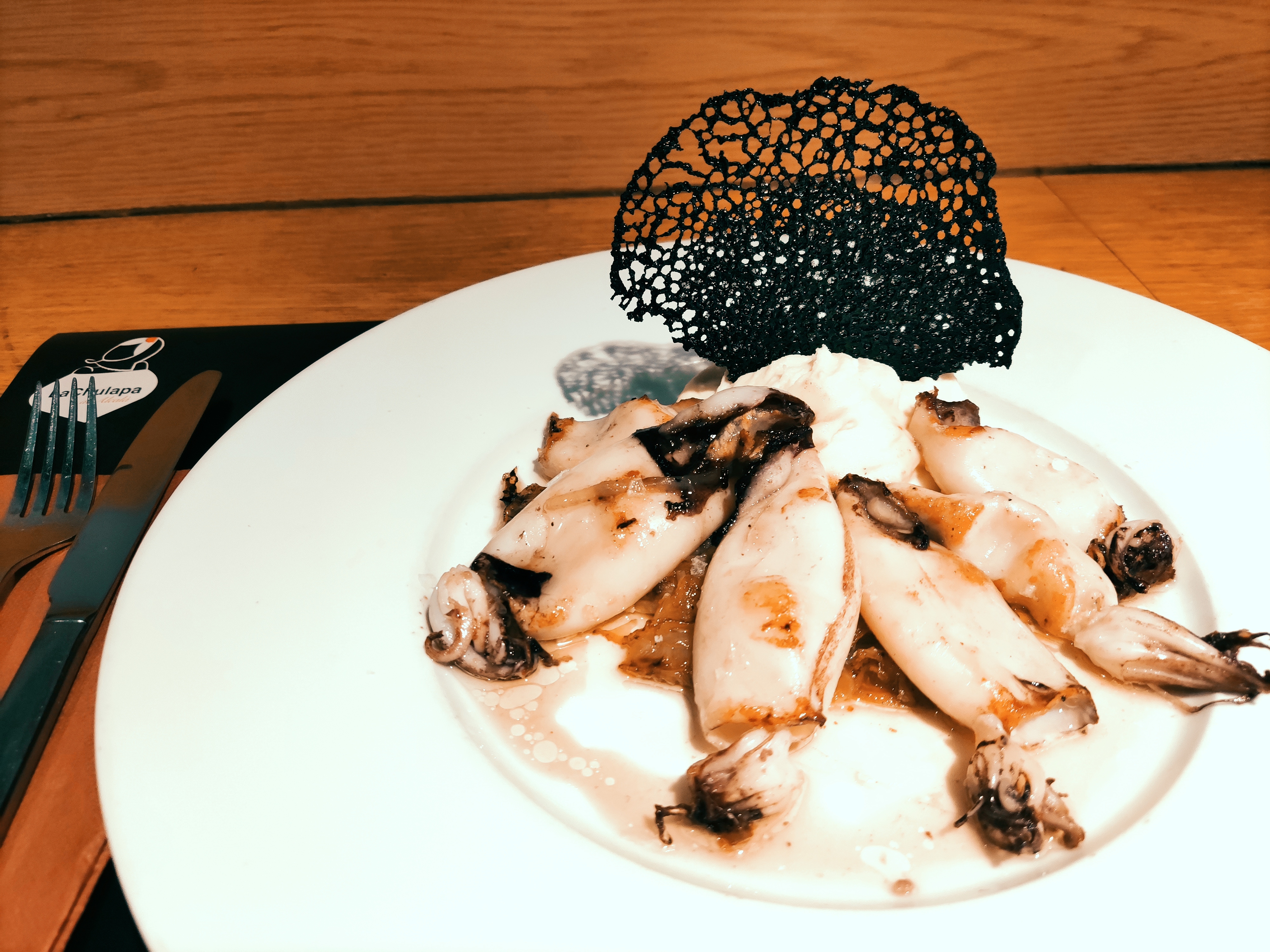 Grilled squid with potato parmentier and squid ink charcoal