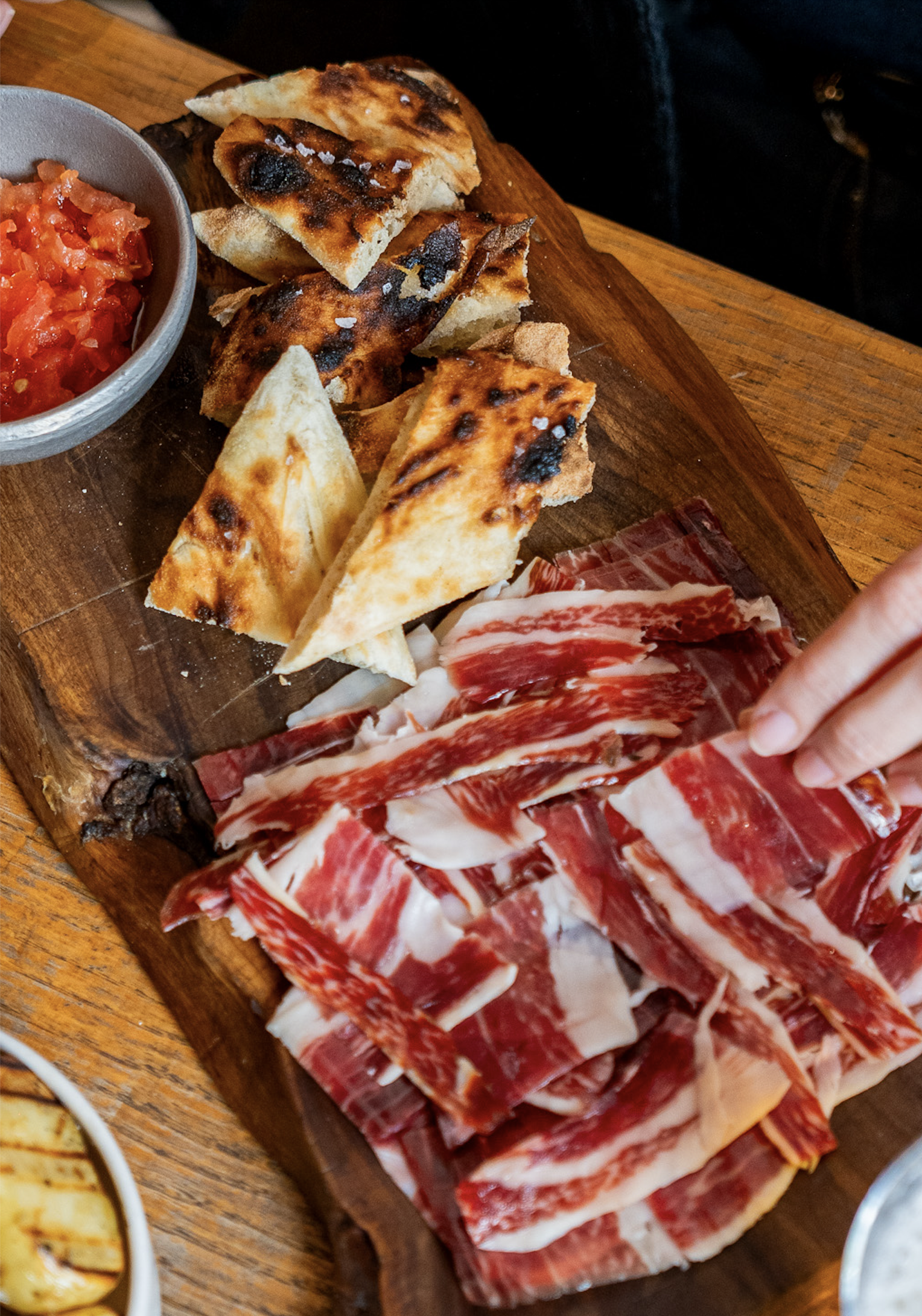 Ibérico-Schinken aus Eichelmast (100 g), frisch gebackenes Brot und geriebene Tomaten