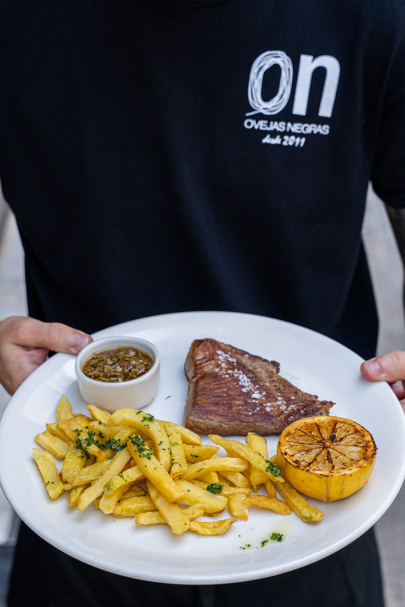 Secreto ibérico al limón, patatas fritas y chimichurri de hierbas