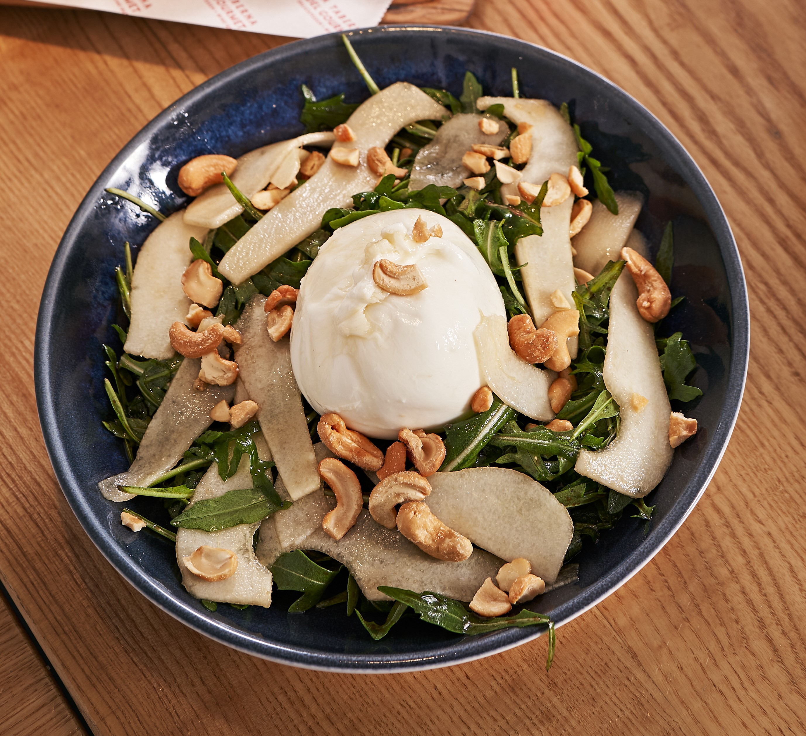 Ensalada de burrata, rúcula, pera, anacardos y miel