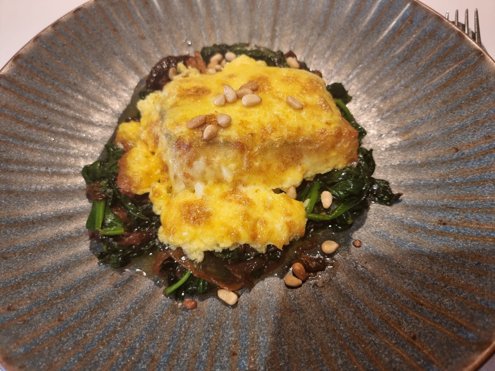 Bacalao gratinado, espinacas, ciruelas y tomate seco