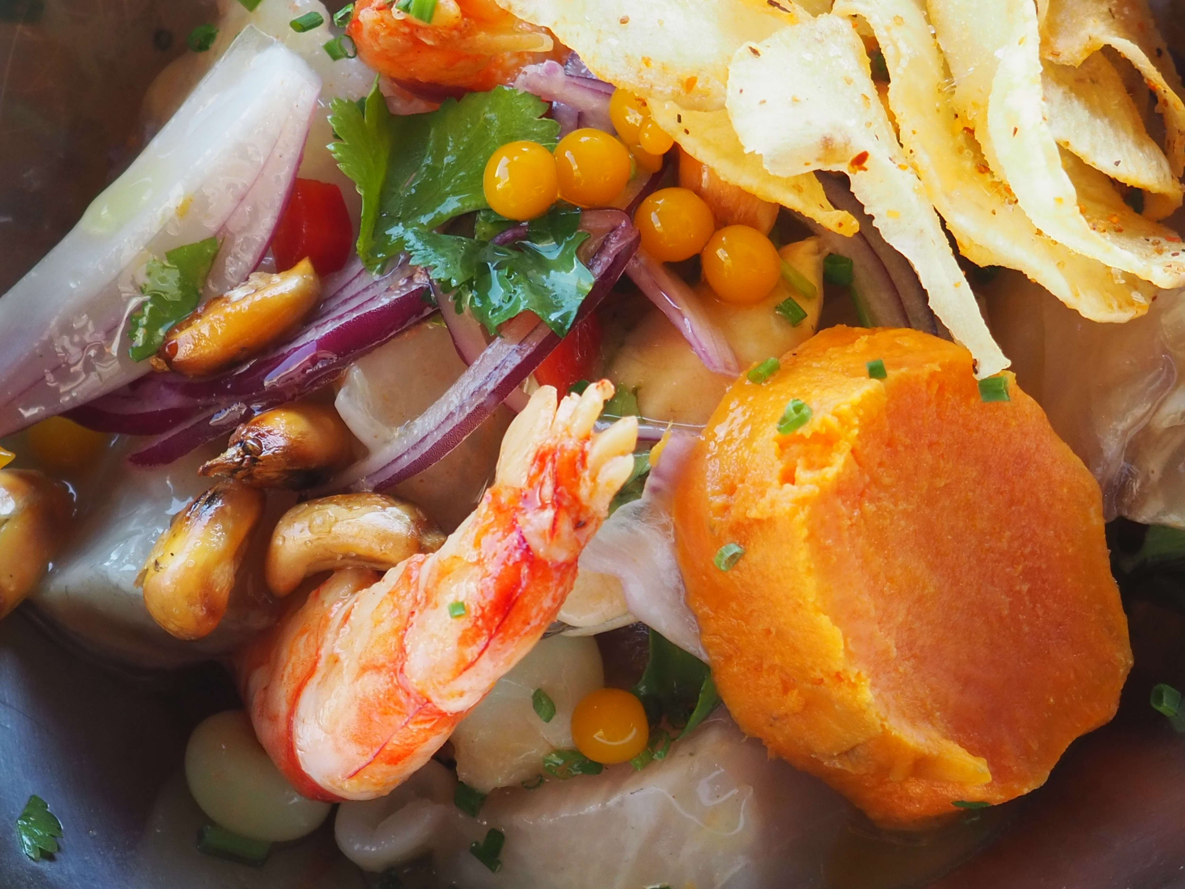 Cebiche de corvina y mariscos con guarnición de choclo,, Yuca y Batata