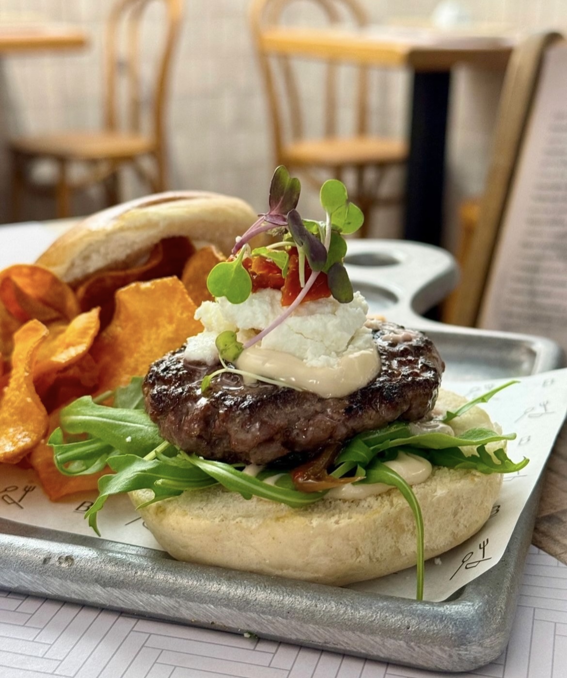 Beef burger with caramelized onion, goat cheese, potatoes chips