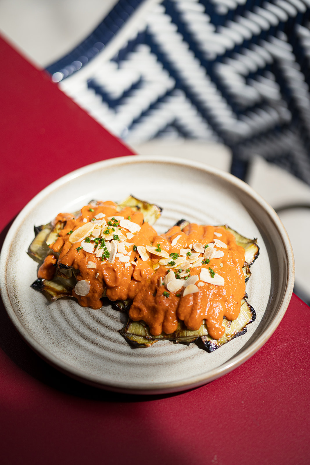 Alcachofa a la brasa con salsa romesco y almendra laminada