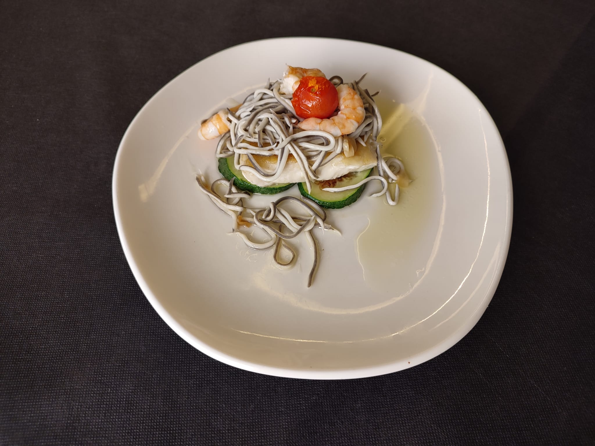 Merluza con gulas y langostinos al ajillo sobre nido de calabacín (160gr.)