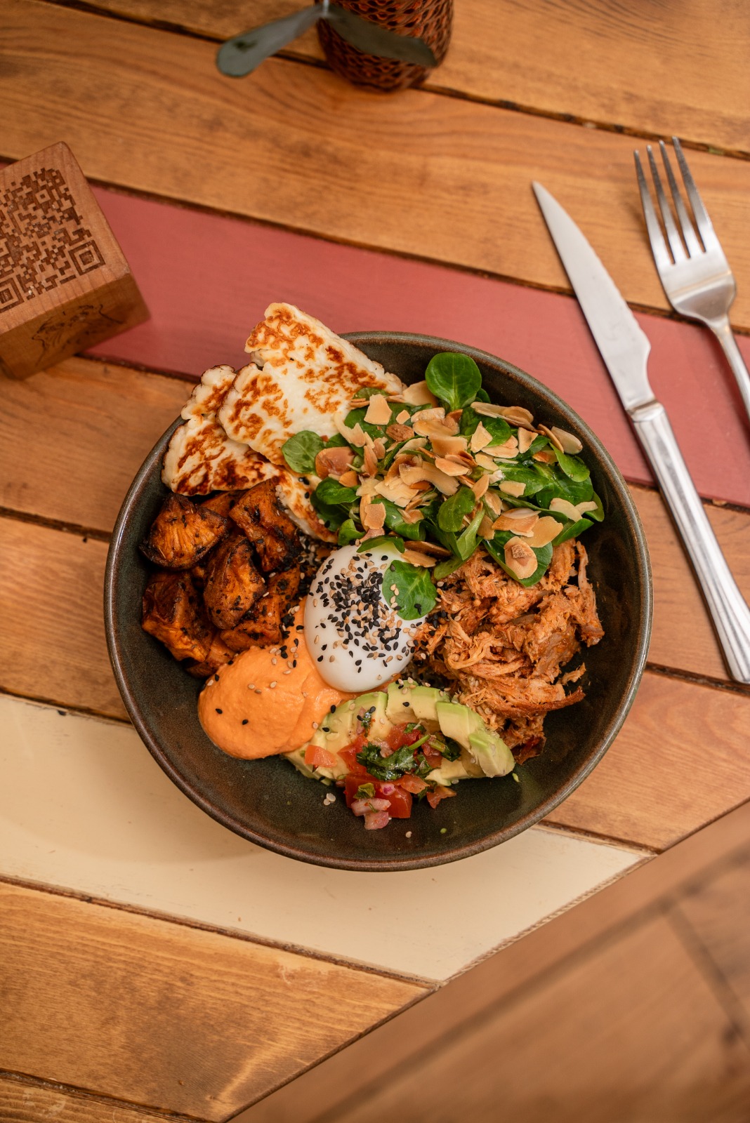 CIOTOLA PER IL PERSONALE: a base di quinoa con formaggio hallumi, un uovo, avocado, hummus di barbabietola, maiale sfilacciato, lattuga di agnello, pico de gallo e salsa di sesamo