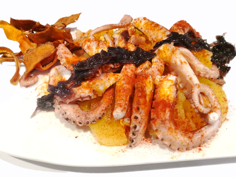 Grilled octopus in Galicia style. With baked potatoes