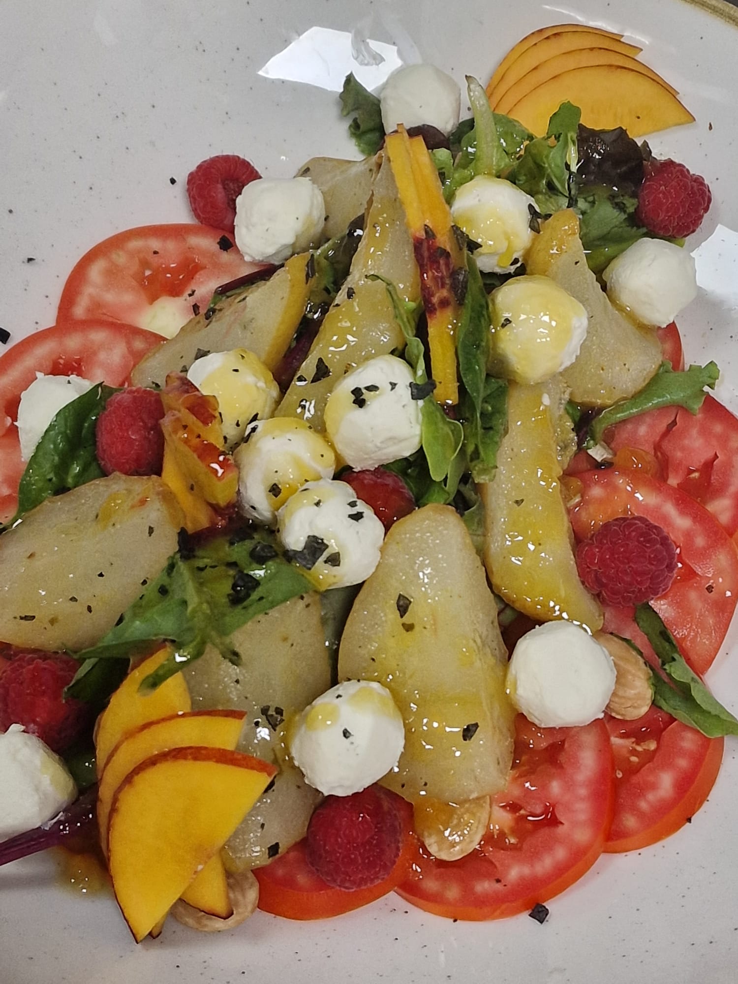 Ensalada de queso de cabra con peras confitadas, almendras y brotes tiernos con vinagreta de melocotón