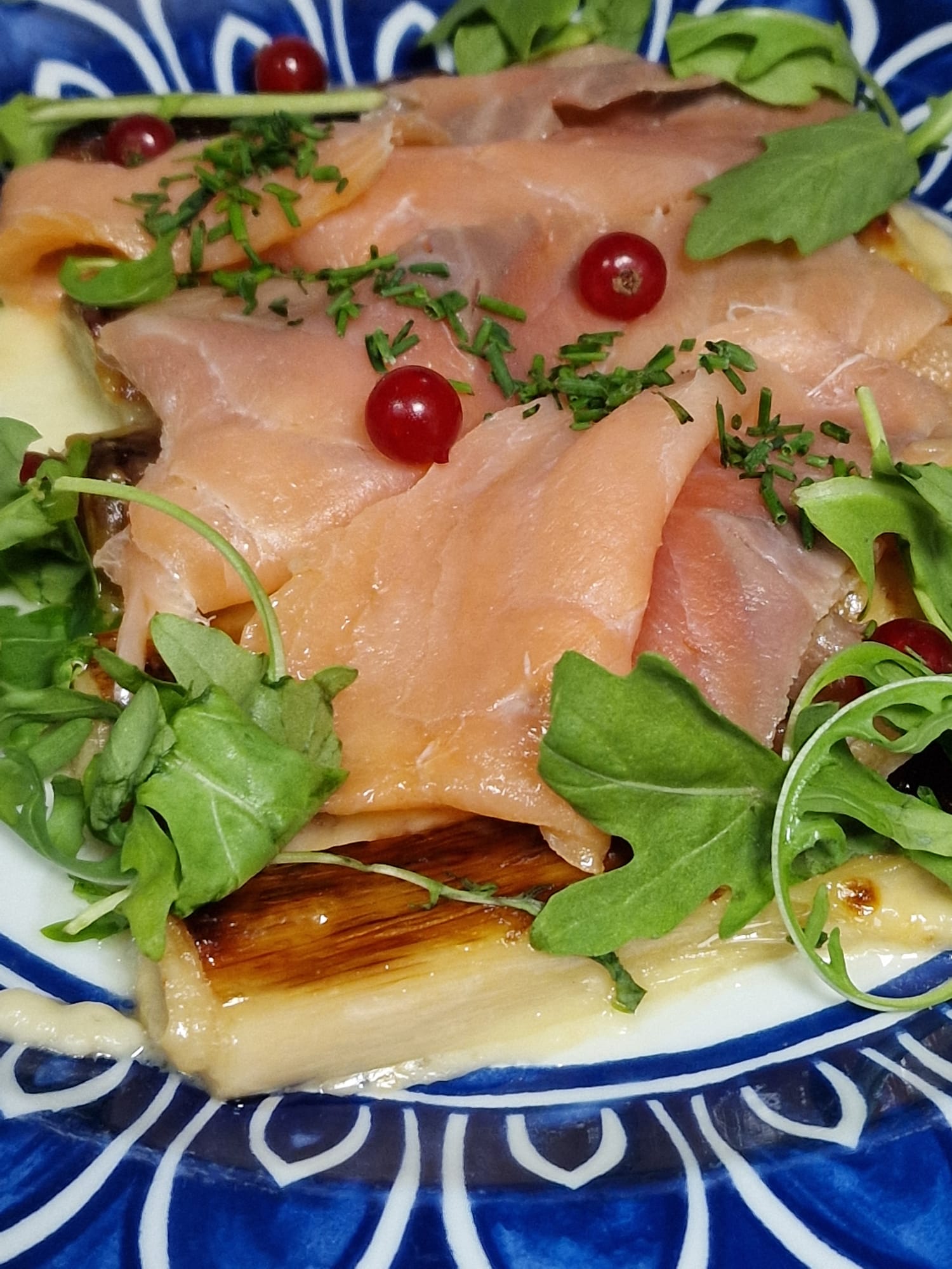 Puerros confitados gratinados con holandesa, laminas de salmón y esferas de aceite