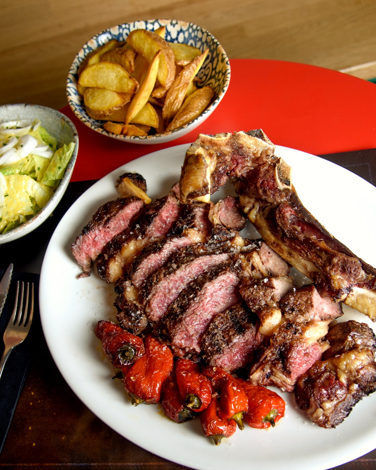 Galician Friesian T-bone steak with chips, green salad and roasted peppers