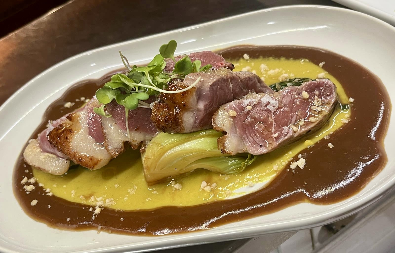 Magret de pato con pak choi crema de coco curry y cacahuete