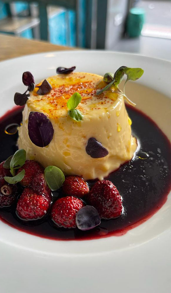 Flan de huevo con jugo de cerezas y fresas silvestres