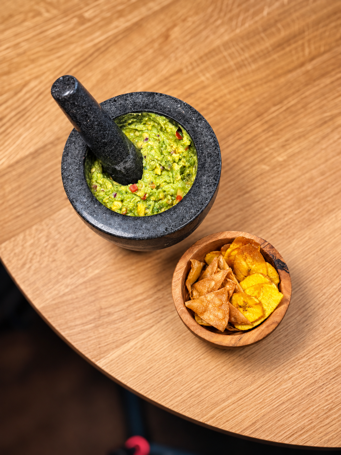 Guacamole in un molcajete con totopos, servito su un tavolo