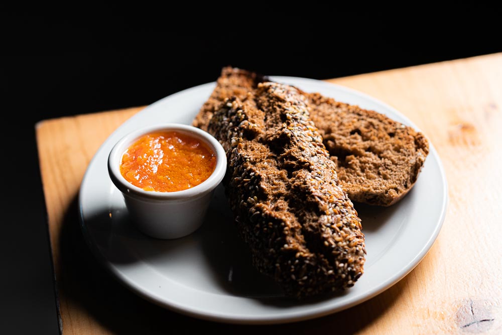Café con barrita de pan de semillas, tomate y aceite.