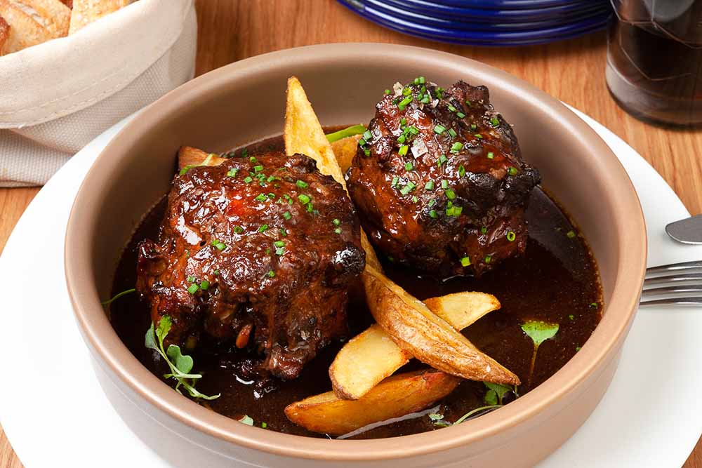 Rabo de toro estofado al vino tinto con patatas rústicas 