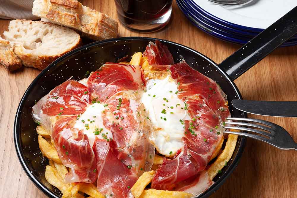 Scrambled eggs with iberian ham and potatoes 